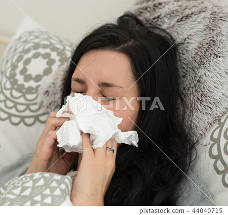 Young woman having flu, blowing her nose. Young woman having flu, blowing her nose. 44040715