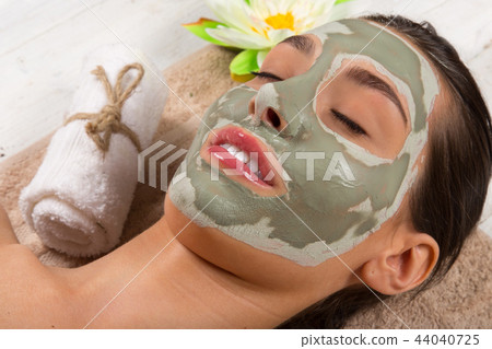 Young healthy woman with face clay mask. Young healthy woman with face clay mask. 44040725