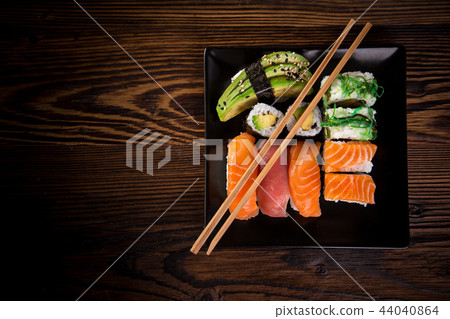 Various kinds of sushi served on wooden table. 44040864