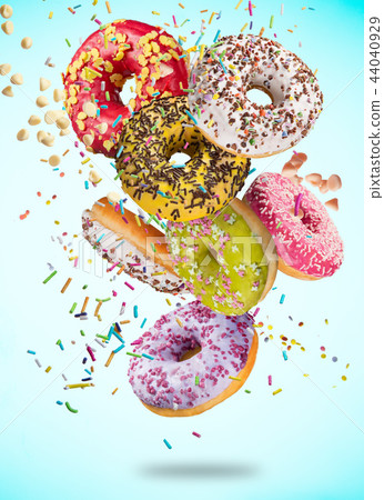 Tasty doughnuts in motion falling on pastel blue background. 44040929