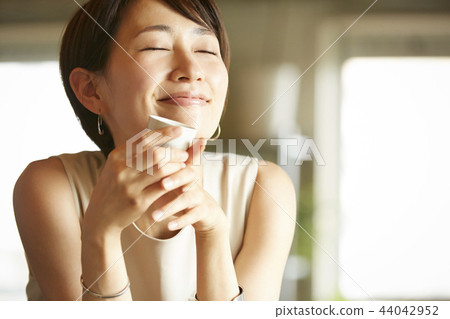 Woman drinking alcohol in a room 44042952