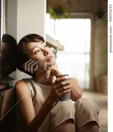 Woman drinking alcohol in a room Woman drinking alcohol in a room 44043245