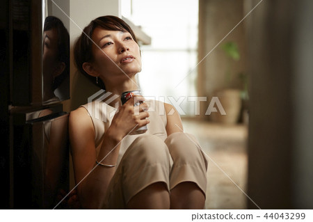 Woman drinking alcohol in a room 44043299