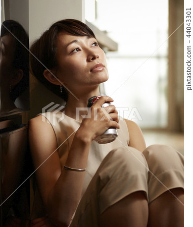 Woman drinking alcohol in a room 44043301