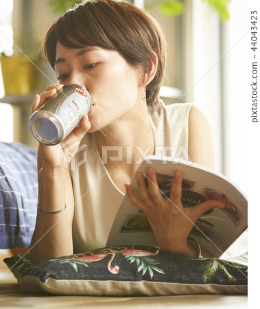 Woman drinking alcohol in a room Woman drinking alcohol in a room 44043423