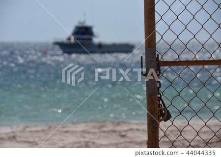 Wire mesh, sandy beach and sea (Western Australia Cervantes) 44044335