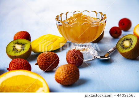 Jam of tropical fruits on a wooden table. Jam of tropical fruits on a wooden table. 44052563