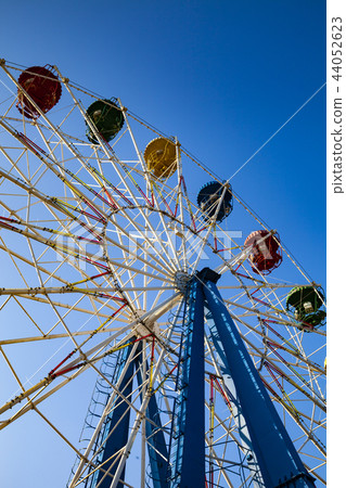 Ferris wheel against the blue sky. Ferris wheel against the blue sky. 44052623