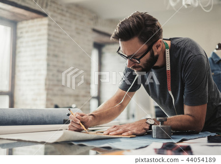 Fashion designer working in his studio Fashion designer working in his studio 44054189