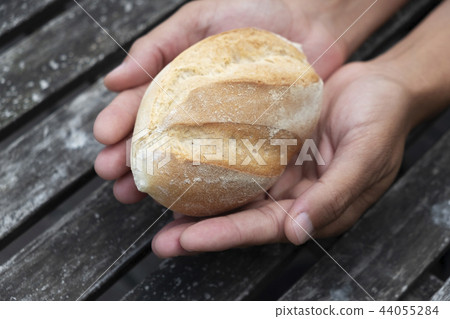 man with a bread roll in his hands 44055284