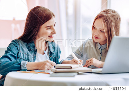 Cheerful pupils doing home tasks with pleasure Cheerful pupils doing home tasks with pleasure 44055504