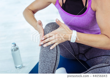 Female hands maintaining muscle in stretched position Female hands maintaining muscle in stretched position 44056843