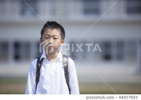 A boy carrying a school bag A boy carrying a school bag 44057693