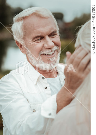 Happy bearded man enjoying pleasant communication with his wife Happy bearded man enjoying pleasant communication with his wife 44057803