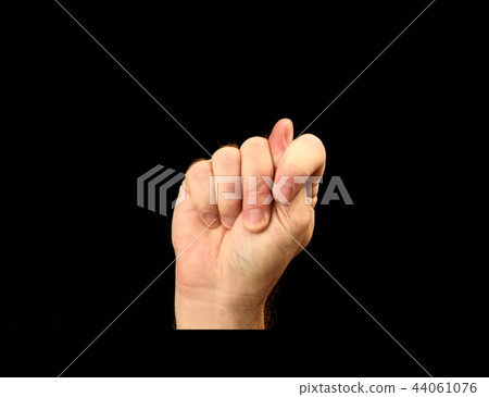 Man's hand shows gesture fig isolated on black 44061076