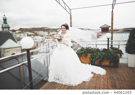 Portrait of stunning bride with long hair posing with great bouquet 44061265