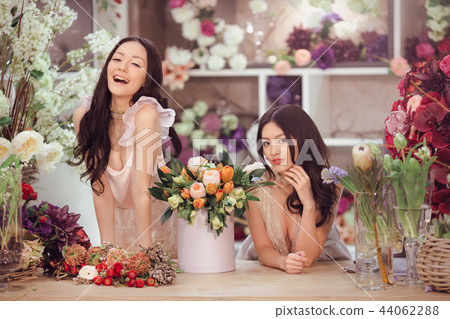 Beautiful asian women florists with bouquet of flowers in flower store Beautiful asian women florists with bouquet of flowers in flower store 44062288
