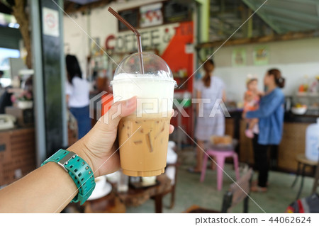 Hand hold fresh iced coffee in coffee cafe Hand hold fresh iced coffee in coffee cafe 44062624