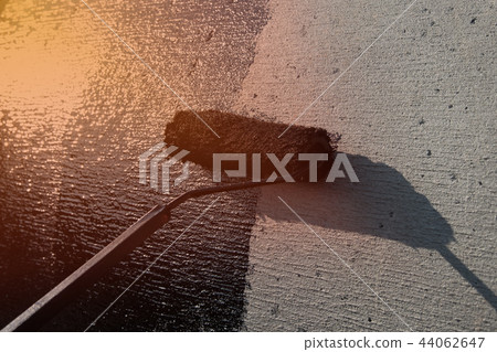 Roofer worker painting black coal tar or bitumen 44062647