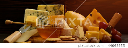 Various types of cheese on a rustic wooden table 44062655