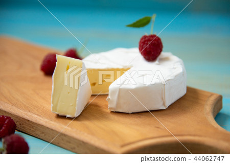 cheese camembert with raspberries and grapes on table 44062747