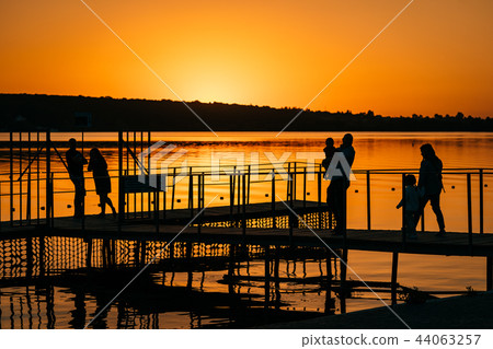 silhouettes of people at the pier, sunset silhouettes of people at the pier, sunset 44063257