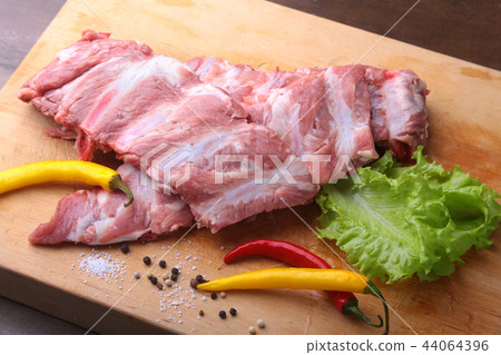 Raw steak on rustic cutting board with salt pepper 44064396