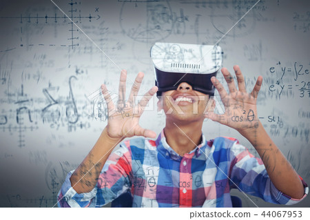 Composite image of happy boy looking through virtual reality simulator while sitting on chair 44067953