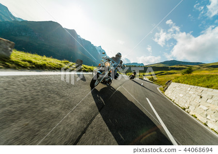 Motorcycle drivers riding in Alpine highway on famous Hochalpenstrasse, Austria, Europe. Motorcycle drivers riding in Alpine highway on famous Hochalpenstrasse, Austria, Europe. 44068694