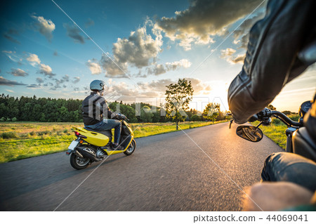Motor biker riding on empty road with sunset light, concept of speed and touring in nature. 44069041