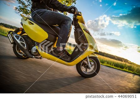 Motor biker riding on empty road with sunset light, concept of speed and touring in nature. 44069051