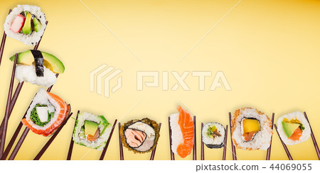 Traditional japanese sushi pieces placed between chopsticks on pastel color background. Traditional japanese sushi pieces placed between chopsticks on pastel color background. 44069055