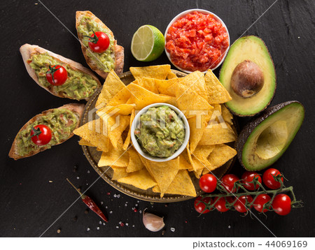 Guacamole with bread and avocado on stone background Guacamole with bread and avocado on stone background 44069169
