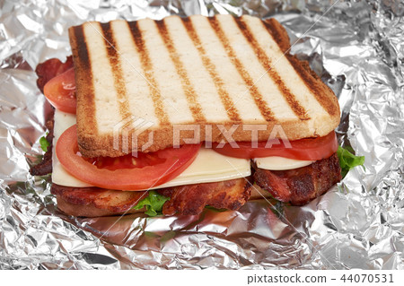 fresh sandwich close up with vegetables and meat on the background of foil 44070531