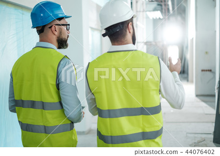 Engineers in hardhats have conversation 44076402