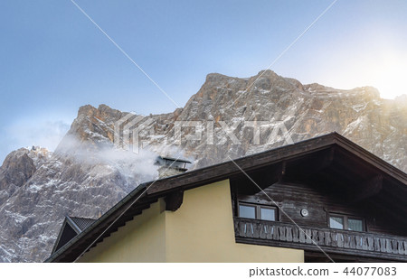 Smoky chimney and the snowy Alps mountains Smoky chimney and the snowy Alps mountains 44077083