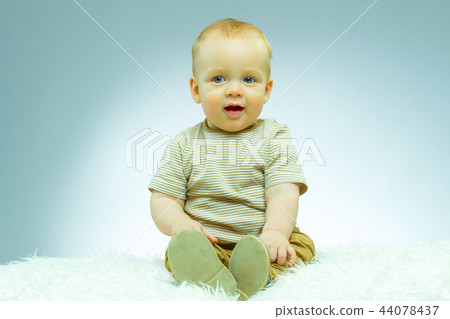 Cute beautiful newborn on a blue background looking at camera and smiling 44078437