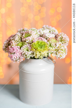 Pink persian buttercup flowers. Curly peony ranunculus in Metallic gray vintage can. Vase with 44080118