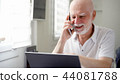 Senior man sitting at home with laptop and smartphone. Using cellphone discussing project on screen 44081788