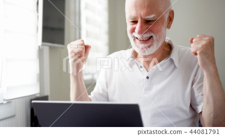 Handsome elderly senior man working on laptop computer at home. Received good news excited and happy Handsome elderly senior man working on laptop computer at home. Received good news excited and happy 44081791