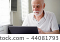 Handsome elderly senior man working on laptop computer at home. Remote freelance work on retirement 44081793