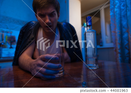 Alcohol addicted man sitting in kitchen at home. Alcohol addicted man sitting in kitchen at home. 44081963