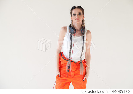 woman with long braids listens to music and dances 44085120