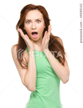 Woman is holding her face in astonishment Woman is holding her face in astonishment 44089142