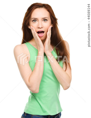 Woman is holding her face in astonishment Woman is holding her face in astonishment 44089144