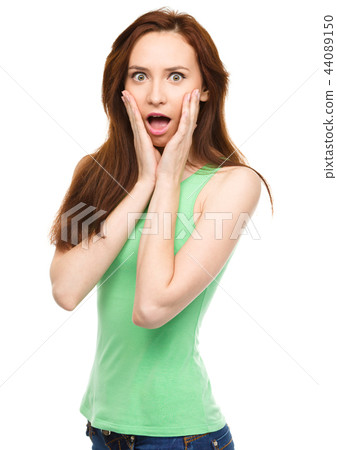 Woman is holding her face in astonishment Woman is holding her face in astonishment 44089150
