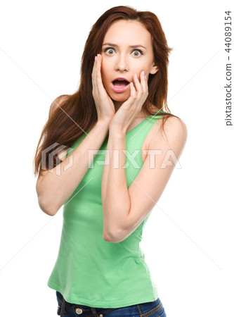 Woman is holding her face in astonishment Woman is holding her face in astonishment 44089154
