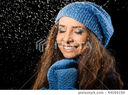 Young happy woman under snowfall Young happy woman under snowfall 44089190