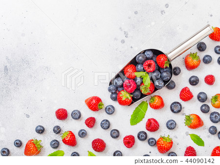 Fresh raw organic berries in steel scoop spoon Fresh raw organic berries in steel scoop spoon 44090142