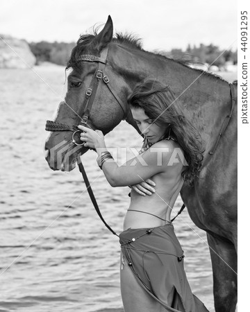 horse and young naked Amazon woman on river shore 44091295